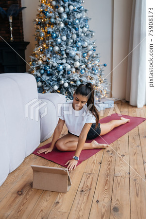 Beautiful woman practising yoga near window at morning. Beautiful woman practising yoga near window at morning. 75908173