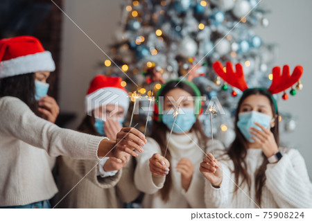 Multi-ethnic young people celebrating New year eve holding sparklers 75908224