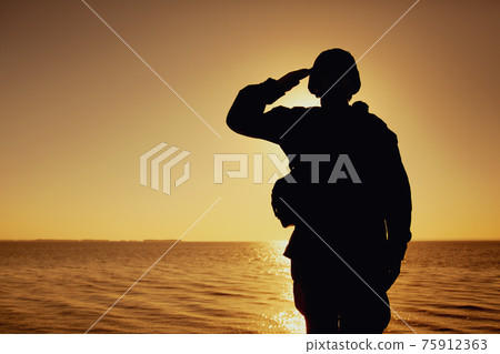 Silhouette of soldier salutes on sunset background 75912363