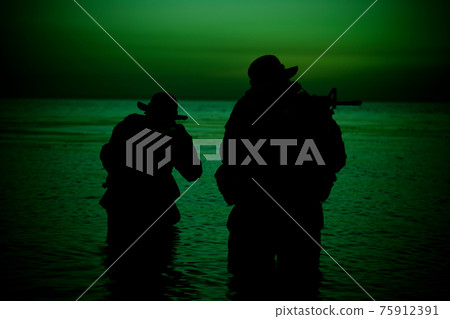 Coast guard soldiers landing on shore at sunset Coast guard soldiers landing on shore at sunset 75912391