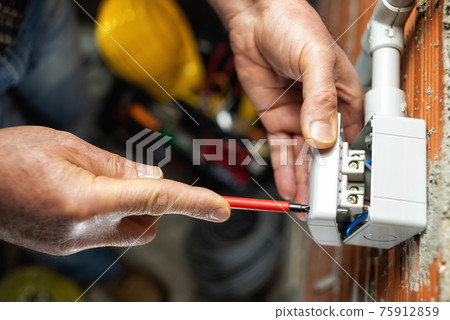 Electrician at work on a residential electrical system. Electricity. Electrician at work on a residential electrical system. Electricity. 75912859