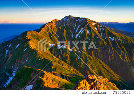 View of Mt. Goryu in the Northern Alps illuminated by the setting sun from Mt. Karamatsu 75915031