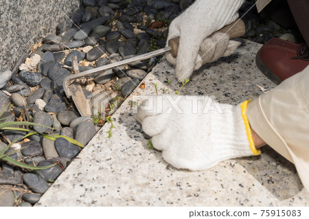 Weeding work on the grave 75915083