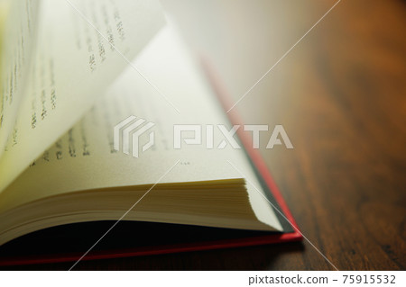 Turn over a book on a bright background. Turn over a book on a bright background. 75915532