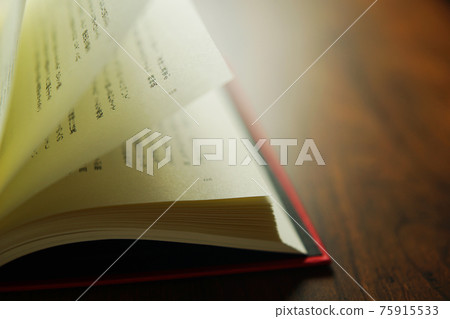 Turn over a book on a bright background. 75915533