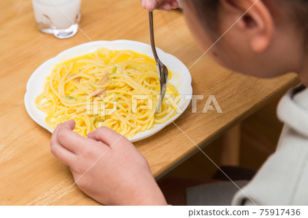 Children eating carbonara for lunch 75917436