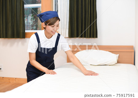 A woman who is a housekeeper who makes a bed 75917591