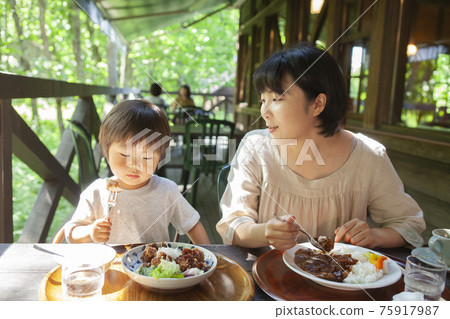 Parents and children enjoying eating out on the terrace 75917987