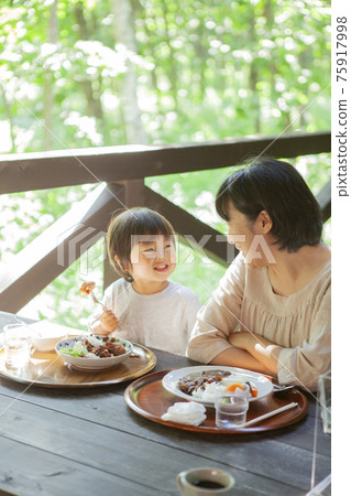 Parents and children enjoying eating out on the terrace 75917998