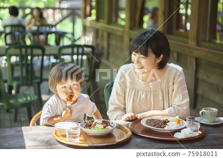 Parents and children enjoying eating out on the terrace 75918011
