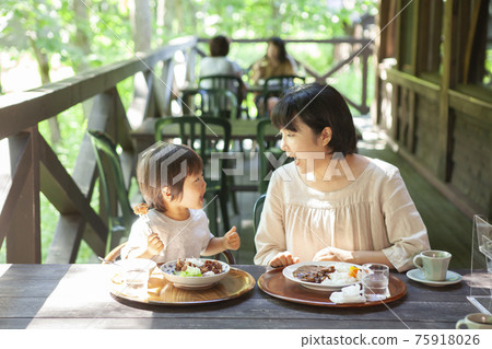 Parents and children enjoying eating out on the terrace 75918026