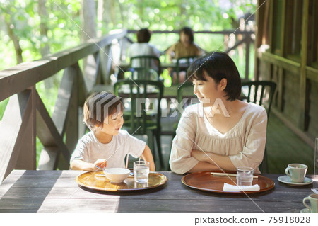 Parents and children enjoying eating out on the terrace 75918028