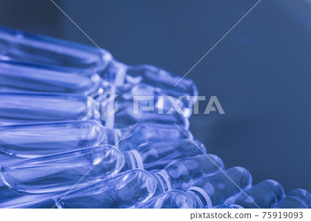Glass medical ampoule vial for injection. Medicine is liquid sodium chloride with of aqueous solution in ampulla. Close up. Bottles ampule multicolor. 75919093