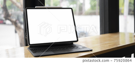 Close up view of computer tablet with blank screen on wooden table near window. Close up view of computer tablet with blank screen on wooden table near window. 75920864