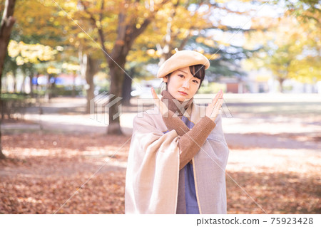 A woman making a cross in an autumn park A woman making a cross in an autumn park 75923428