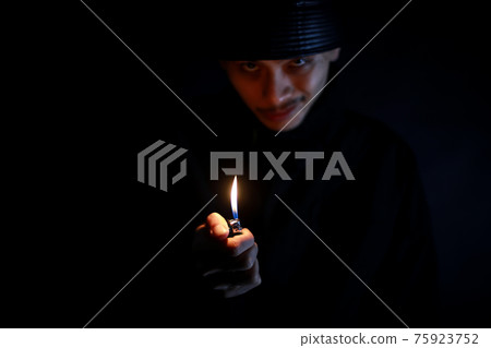 Crime image of a man who ignites with a lighter 75923752