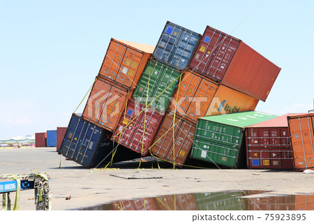 A container yard where stacked marine containers collapsed due to the storm surge of a typhoon 75923895