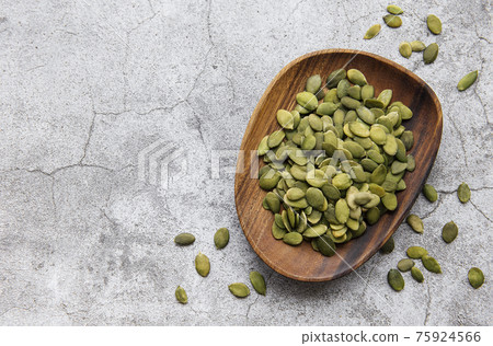 Wooden plate with pumpkin seeds Wooden plate with pumpkin seeds 75924566