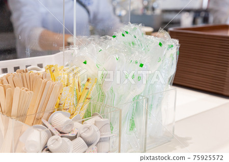 Plastic spoon, wooden muddler, coffee milk placed on the counter of the restaurant Plastic spoon, wooden muddler, coffee milk placed on the counter of the restaurant 75925572