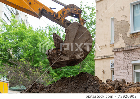 Excavator bucket pours ground. Repair work plumbing. 75926902
