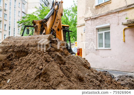 Excavator bucket pours ground. Repair work plumbing. 75926904