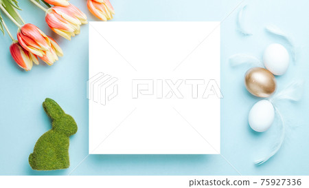 Easter spring. Golden, white colour egg in basket with spring tulips, feathers on pastel blue background in Happy Easter decoration. Spring holiday top view concept. Easter spring. Golden, white colour egg in basket with spring tulips, feathers on pastel blue background in Happy Easter decoration. Spring holiday top view concept. 75927336