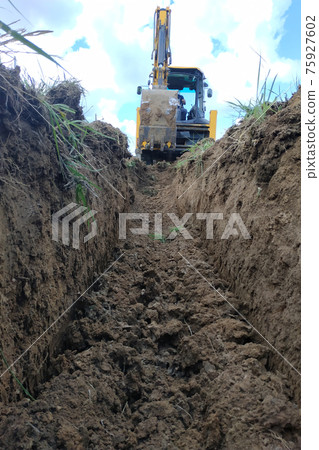 Wiring of an electric cable on the dug trench, supply of the electric power to the house on the earth. 75927602