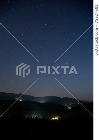 Starry sky over the mountains and mountain village. Starry sky over the mountains and mountain village. 75927983