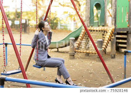 一位年輕女子的西裝暮色在公園裡 75928146