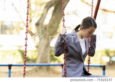 一位年輕女子的西裝暮色在公園裡 75928147
