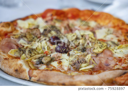 homemade pizza with ham, olives and artichoke homemade pizza with ham, olives and artichoke 75928897