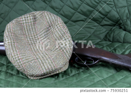 Vintage Shotgun with Cloth Cap on a Green Country Coat Vintage Shotgun with Cloth Cap on a Green Country Coat 75930251