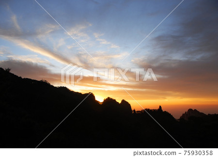 Huangshan Mountain in Anhui Province, China. After sunset on Huangshan with colorful sky and clouds and a silhouette of the mountain. Sunset near the summit of Huangshan Mountain, China. Huangshan Mountain in Anhui Province, China. After sunset on Huangshan with colorful sky and clouds and a silhouette of the mountain. Sunset near the summit of Huangshan Mountain, China. 75930358