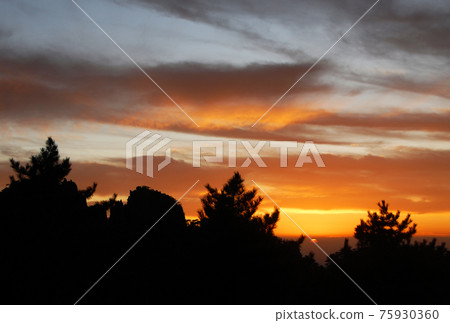 Huangshan Mountain in Anhui Province, China. Sunset over Huangshan with colorful sky and clouds and a silhouette of the trees. Sun nearly set. Sunset near the summit of Huangshan Mountain, China. Huangshan Mountain in Anhui Province, China. Sunset over Huangshan with colorful sky and clouds and a silhouette of the trees. Sun nearly set. Sunset near the summit of Huangshan Mountain, China. 75930360
