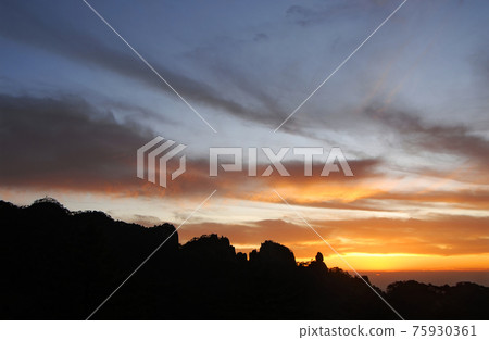 Huangshan Mountain in Anhui Province, China. Sunset over Huangshan with colorful sky and clouds and a silhouette of the mountain. Sun nearly set. Sunset near the summit of Huangshan Mountain, China. Huangshan Mountain in Anhui Province, China. Sunset over Huangshan with colorful sky and clouds and a silhouette of the mountain. Sun nearly set. Sunset near the summit of Huangshan Mountain, China. 75930361