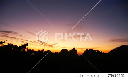 Huangshan Mountain in Anhui Province, China. View after sunset on Huangshan with a colorful purple sky, clouds and a silhouette of the mountain. Sunset near the summit of Huangshan Mountain, China. 75930362