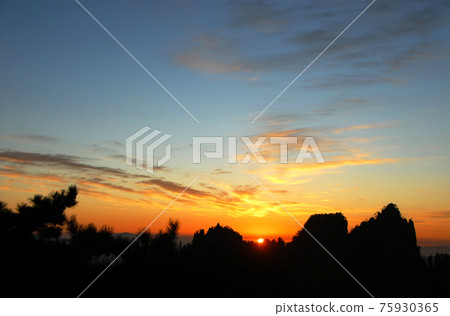 Huangshan Mountain in Anhui Province, China. Sunrise over Huangshan with a colorful sky, clouds, pine trees and silhouette of the mountain. Sunrise near the summit of Huangshan Mountain, China. Huangshan Mountain in Anhui Province, China. Sunrise over Huangshan with a colorful sky, clouds, pine trees and silhouette of the mountain. Sunrise near the summit of Huangshan Mountain, China. 75930365