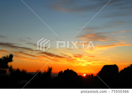 Huangshan Mountain in Anhui Province, China. Sunrise over Huangshan with a colorful sky, clouds, pine trees and silhouette of the mountain. Sunrise near the summit of Huangshan Mountain, China. 75930366