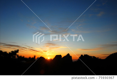 Huangshan Mountain in Anhui Province, China. Sunrise over Huangshan with a colorful sky, clouds, pine trees and silhouette of the mountain. Sunrise near the summit of Huangshan Mountain, China. Huangshan Mountain in Anhui Province, China. Sunrise over Huangshan with a colorful sky, clouds, pine trees and silhouette of the mountain. Sunrise near the summit of Huangshan Mountain, China. 75930367