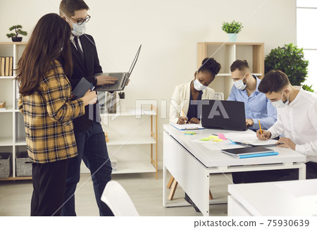 Business people in face mask coworking in reopen office after lockdown Business people in face mask coworking in reopen office after lockdown 75930639
