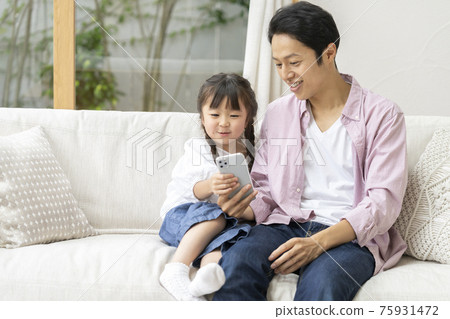 Parent and child (father and daughter) family image looking at smartphone Parent and child (father and daughter) family image looking at smartphone 75931472