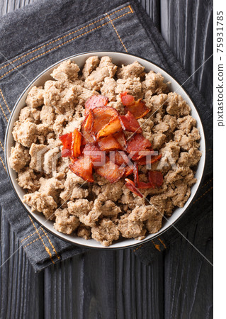 Ajdovi zganci Slovenian national dish of buckwheat flour and fried bacon close-up in a bowl. vertical top view 75931785