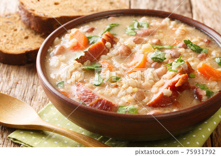 Homemade Ricet barley and bean soup with smoked meat and vegetables close-up in a bowl. horizontal Homemade Ricet barley and bean soup with smoked meat and vegetables close-up in a bowl. horizontal 75931792
