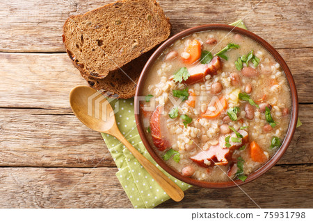 Homemade Ricet barley and bean soup with smoked meat and vegetables close-up in a bowl. horizontal top view Homemade Ricet barley and bean soup with smoked meat and vegetables close-up in a bowl. horizontal top view 75931798