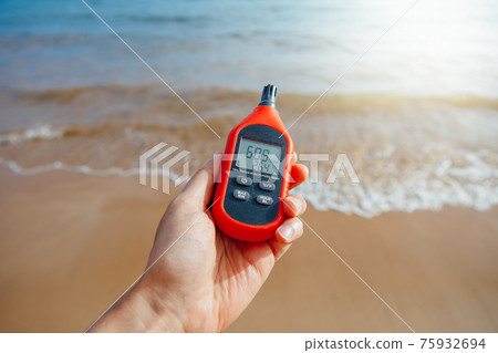 portable thermometer in hand measuring outdoor air temperature and humidity 75932694