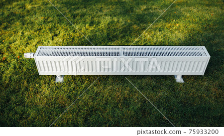 radiator on green lawn, ecological heating concept 75933200