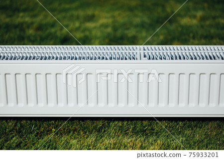 radiator on green lawn, ecological heating concept radiator on green lawn, ecological heating concept 75933201
