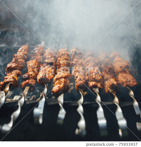 grilled barbecue meat on skewers with smoke 75933937