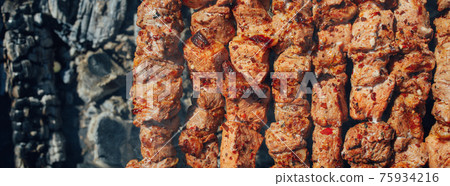 grilled barbecue meat on skewers and charcoals, top view grilled barbecue meat on skewers and charcoals, top view 75934216