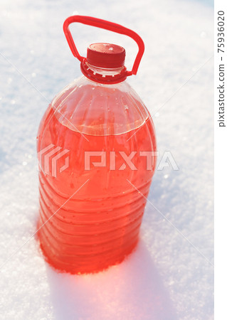bottle with non-freezing windshield washer fluid, snow background 75936020